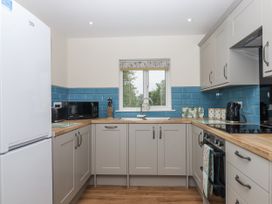 A kitchen with appliances and cabinets at Aunty Junes Cottage Okehampton