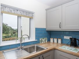A kitchen with a sink and decorative containers at Aunty Junes Cottage Okehampton