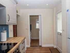 A kitchen with cabinets and a doorway leading to another room at Aunty Junes Cottage in Okehampton