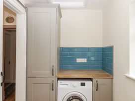 A utility room with a washing machine and cabinet at Aunty Junes Cottage Okehampton