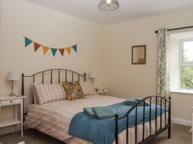 A bedroom with a bed and bedside tables at Aunty Junes Cottage Okehampton