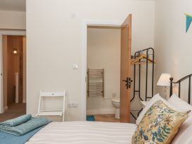 A bedroom with a bed and a door leading to a bathroom at Aunty Junes Cottage Okehampton