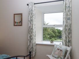 A bedroom with a window and curtains at Aunty Junes Cottage Okehampton