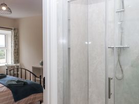 A bedroom with a shower and a bed at Aunty Junes Cottage Okehampton