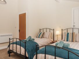 A bedroom with two beds and a bedside table at Aunty Junes Cottage Okehampton