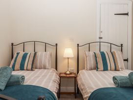 A bedroom with twin beds and a bedside table at Aunty Junes Cottage Okehampton