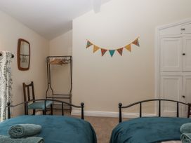 A bedroom with two beds and a wardrobe at Aunty Junes Cottage in Okehampton