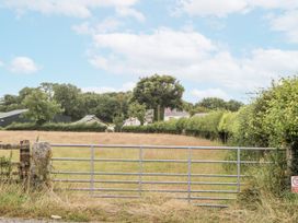 A gate leading to a field with trees and buildings at Aunty Junes Cottage Okehampton