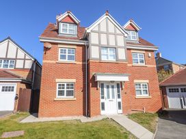 A front view of a brick house with white windows a white front door and a small lawn at 9 Beckett Close in Colwyn Bay