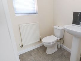A bathroom with a toilet sink radiator and a window at 9 Beckett Close in Colwyn Bay