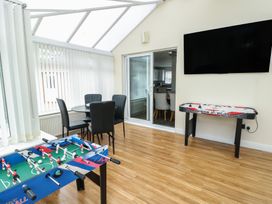 A conservatory with a foosball table and air hockey table at 9 Beckett Close in Colwyn Bay