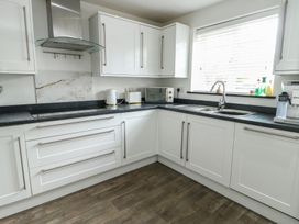A kitchen featuring a sink and microwave at 9 Beckett Close, Colwyn Bay