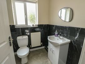 A bathroom with a toilet, sink, and window at 9 Beckett Close Colwyn Bay