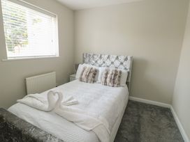 A bedroom with a bed and pillows at 9 Beckett Close in Colwyn Bay
