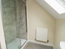 A bathroom with a shower and radiator at 9 Beckett Close in Colwyn Bay