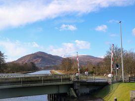 A canal with a bridge and mountains in the background at Crathie Lodge in Banavie near Caol