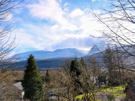 A landscape view of snow-covered mountains with trees and houses in the foreground at Crathie Lodge in Banavie near Caol