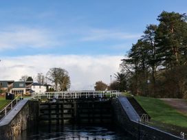 A canal lock with trees and buildings on either side at Crathie Lodge in Banavie near Caol
