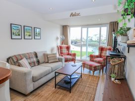 A living room with a sofa and armchairs overlooking a view at Oakley View Apartment in Porthmadog
