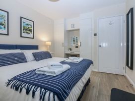 A bedroom with a bed and wall art at Oakley View Apartment in Porthmadog