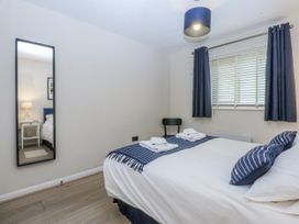 A bedroom with a bed, mirror, and chair at Oakley View Apartment in Porthmadog