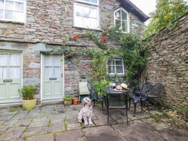 An outdoor seating area with a dog and table at 2 Bakers Yard