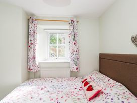 A bedroom with a bed and window at 2 Bakers Yard