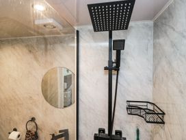 A bathroom with a shower and a mirror at 2 Bakers Yard