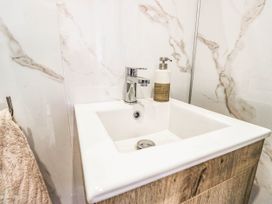 A sink with a faucet and soap dispenser in a bathroom at 2 Bakers Yard