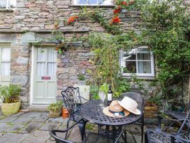 An outdoor area with a table and chairs near stone walls at 2 Bakers Yard