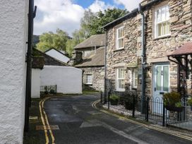 An outdoor view of a stone house and road at 2 Bakers Yard