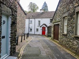 A street scene with stone houses and a red door at 2 Bakers Yard
