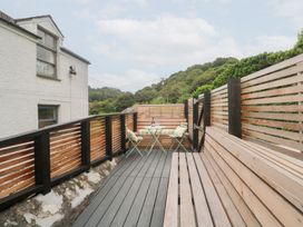 An outdoor area with a wooden deck and seating at Mavericks Wave in St Agnes