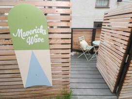 A sign with Mavericks Wave and a seating area at Mavericks Wave in St Agnes