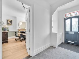 A hallway with a door and a view into the dining area at Palm House in Newquay