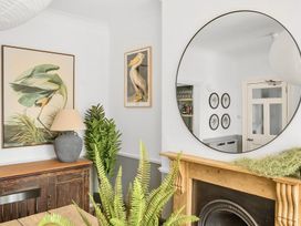 A living room with a painting and a mirror at Palm House in Newquay