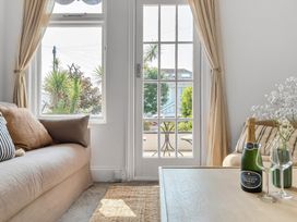 A living room with a sofa and a table at Palm House in Newquay