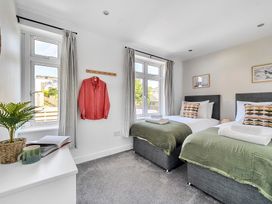 A bedroom with two beds and a shirt hanging at Palm House in Newquay