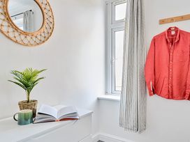 A bedroom with a mirror and shirt hanging at Palm House in Newquay