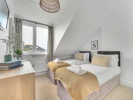 A bedroom with two beds and a window at Palm House in Newquay