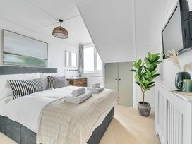 A bedroom with a bed and a television at Palm House in Newquay