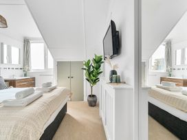 A bedroom with bed and television at Palm House in Newquay