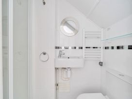 A bathroom with a shower, sink, and toilet at Palm House in Newquay