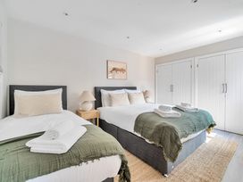 A bedroom with two beds and a wardrobe at Palm House in Newquay