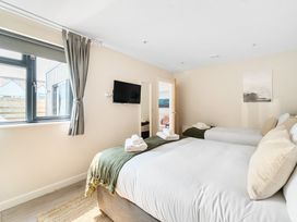 A bedroom with two beds and a television at Palm House in Newquay