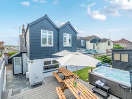 Outdoor seating area with a jacuzzi and garden shed at Palm House in Newquay