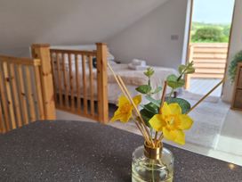 A bedroom with a bed and flowers on a table at The Halt in Maiden Newton
