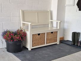 An entryway with a bench and flower planter at The Halt in Maiden Newton