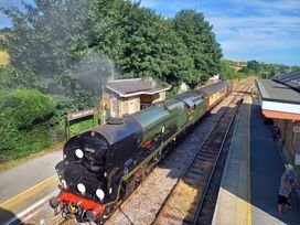 A steam locomotive at a railway station at The Halt in Maiden Newton