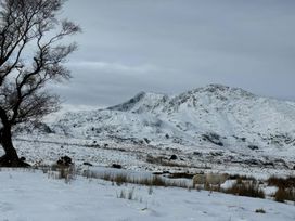 A scenic view of mountains and sheep in snow at Ty Siabod in Capel Curig near Betws-Y-Coed